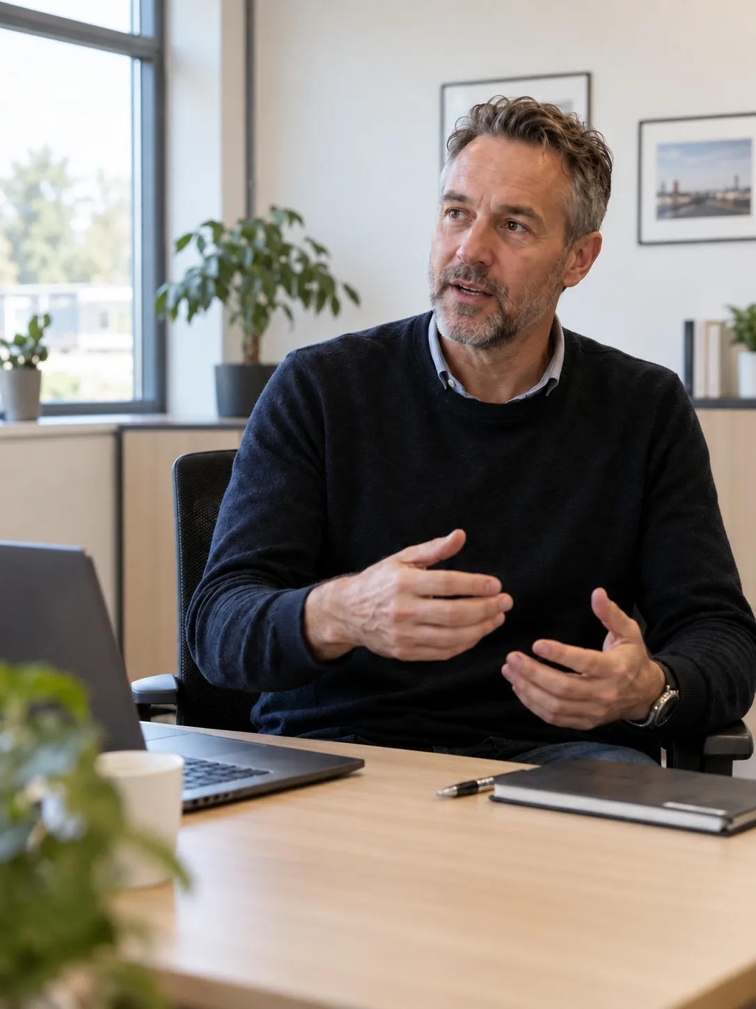 An experienced operations expert explains a work process at his desk.